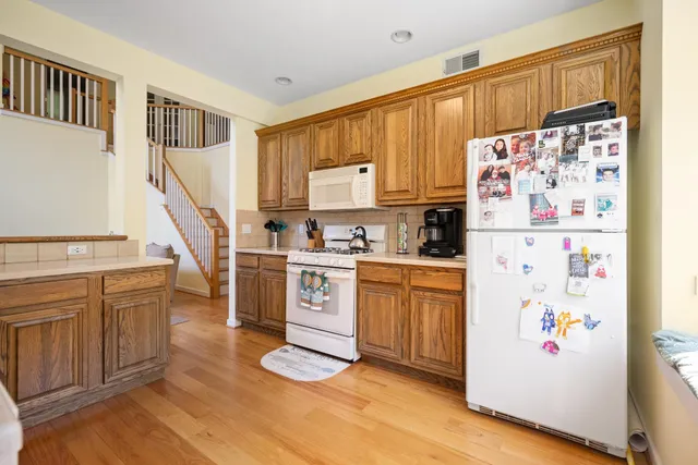 a kitchen with granite countertop a refrigerator a sink and dishwasher