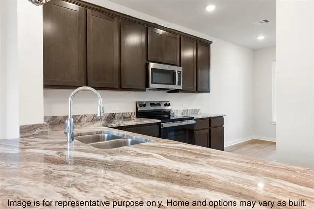 a kitchen with granite countertop stainless steel appliances and cabinets
