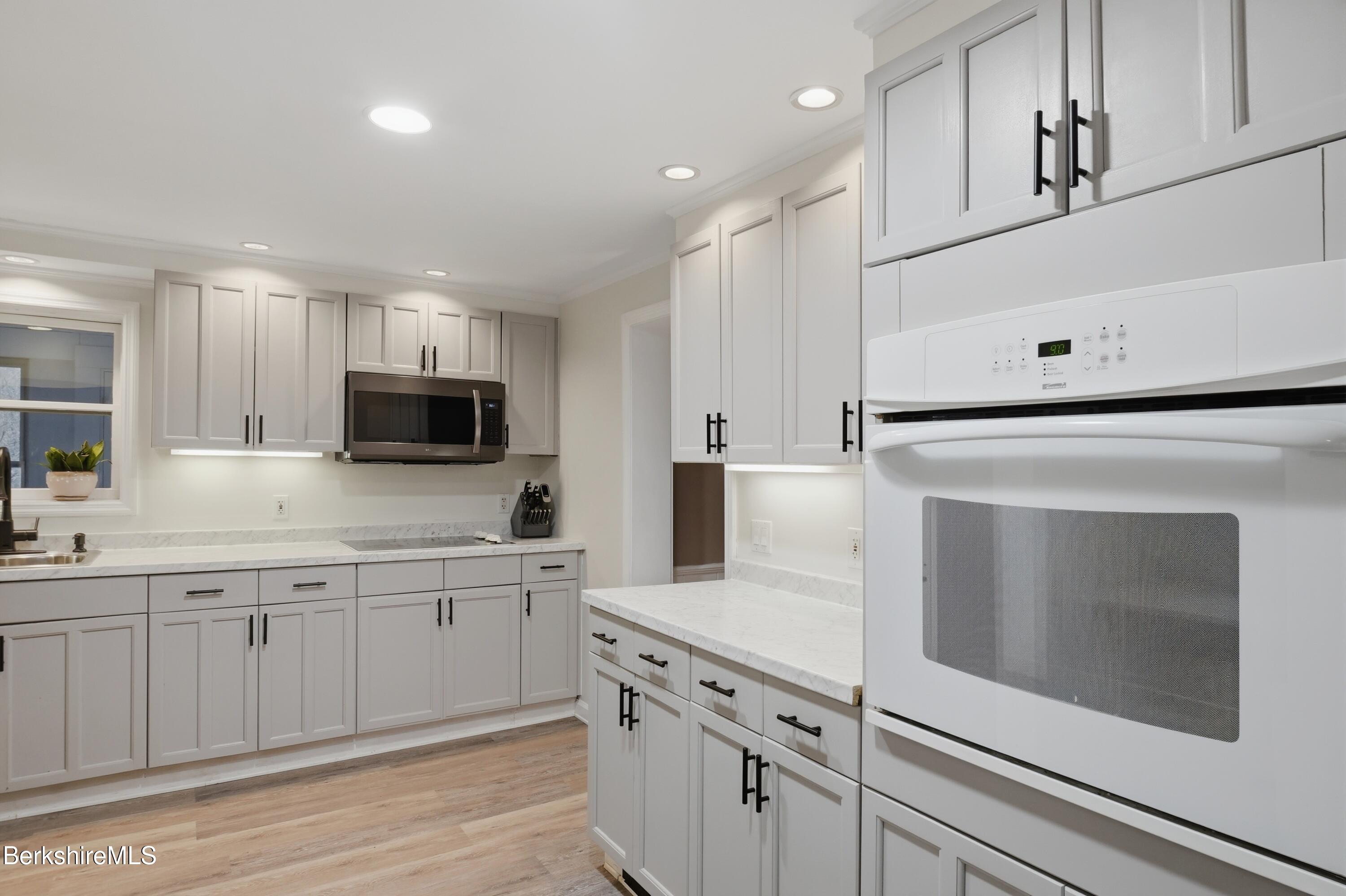 117 Norfolk Road New Marlborough, MA 01259 - Photo 12 of 59 a kitchen with white cabinets and white appliances