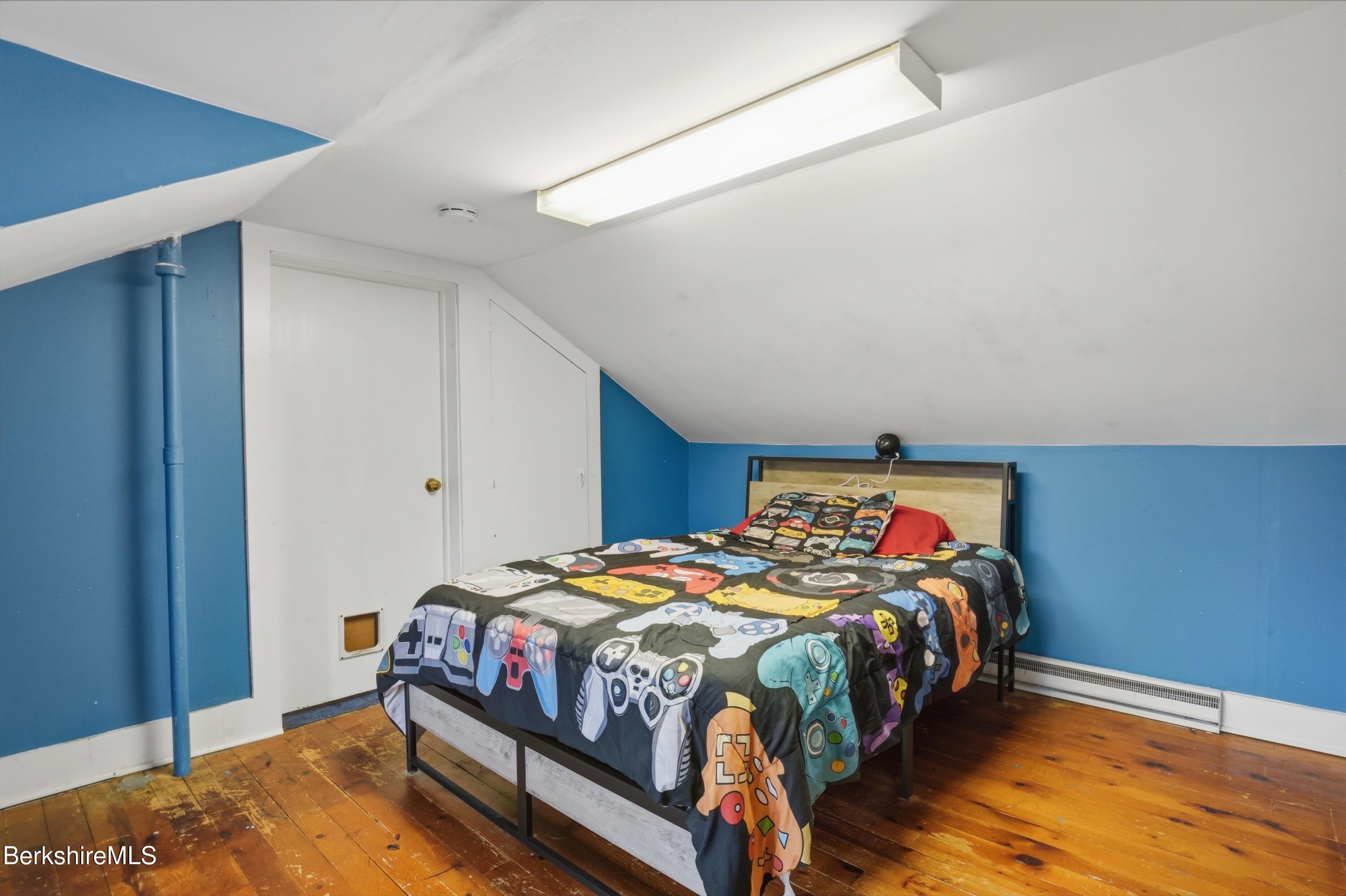 117 Norfolk Road New Marlborough, MA 01259 - Photo 37 of 59 a bedroom with a bed a dresser and wooden floor