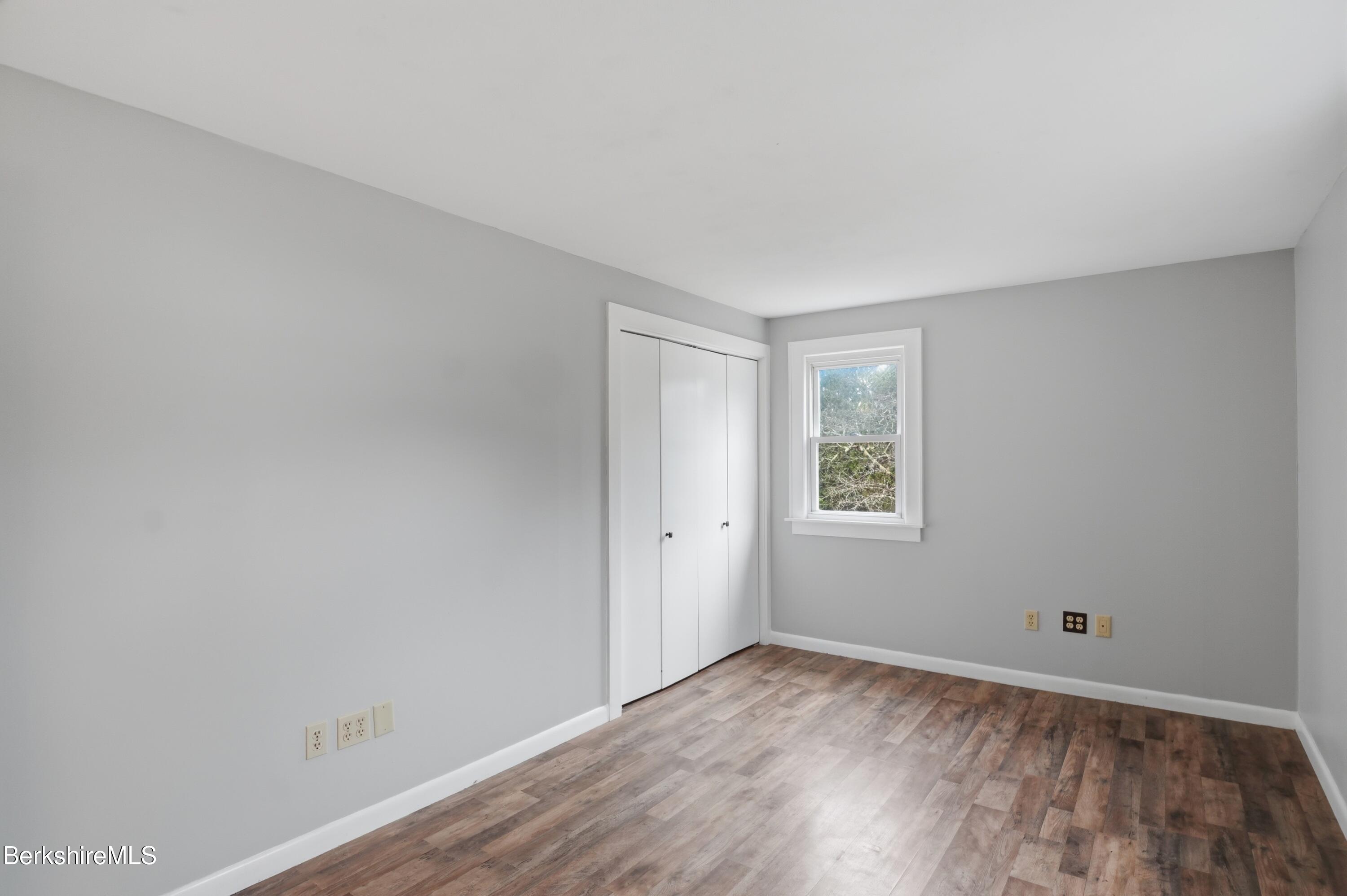117 Norfolk Road New Marlborough, MA 01259 - Photo 43 of 59 a view of an empty room with wooden floor and a window