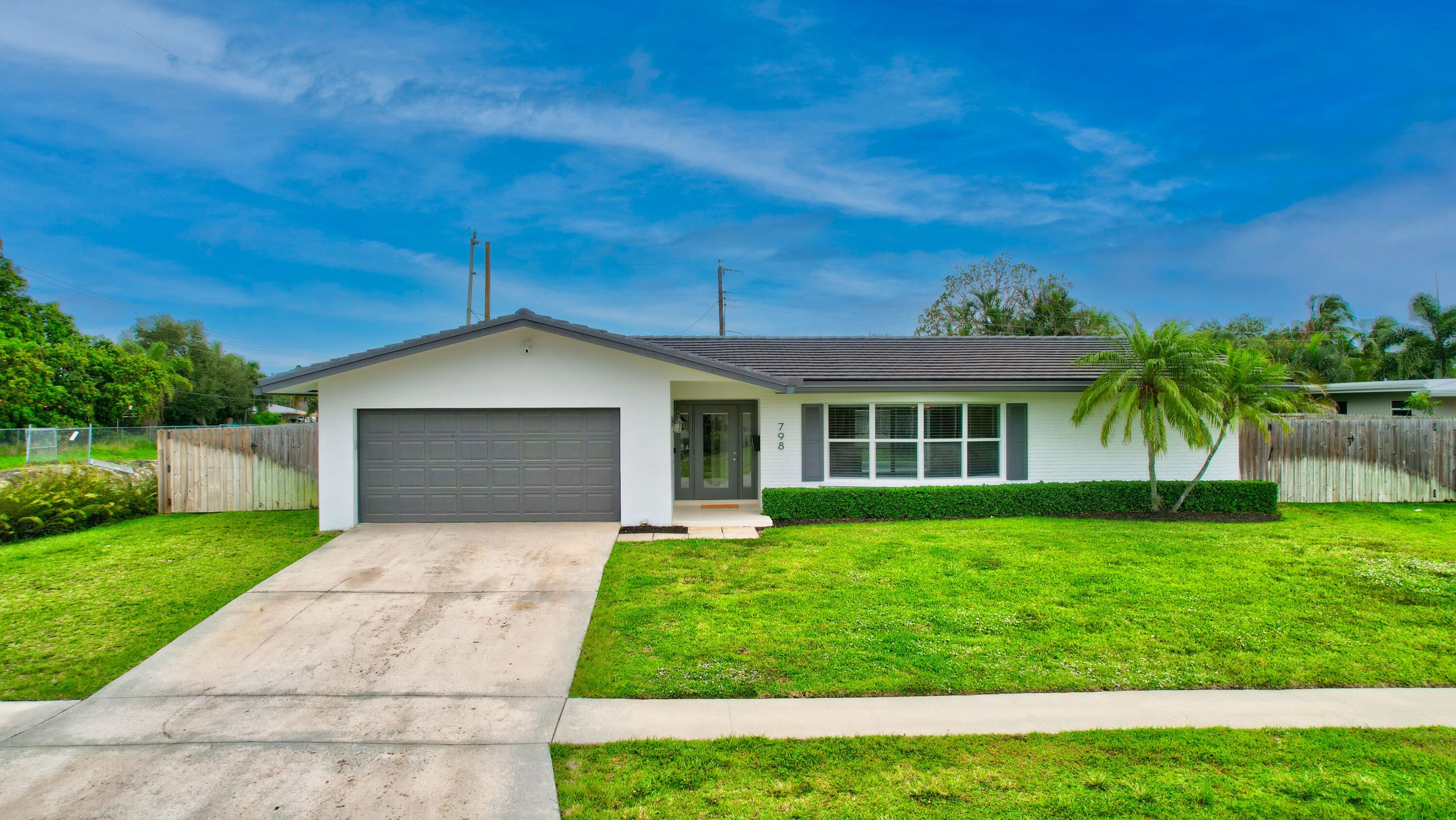 798 Southwest 15th Avenue Boca Raton, FL 33486 - Photo 4 of 27 a front view of a house with a yard and garage