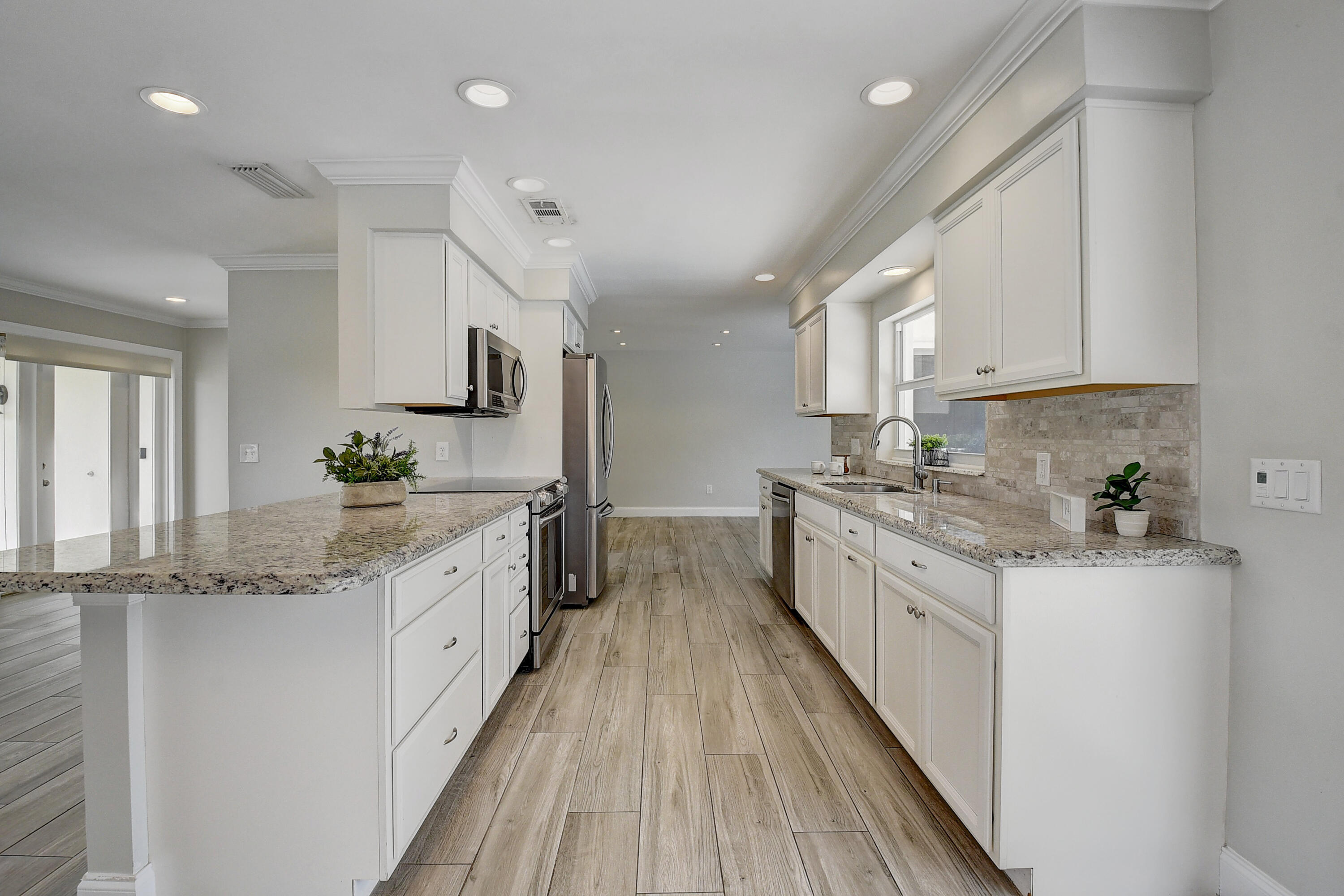 798 Southwest 15th Avenue Boca Raton, FL 33486 - Photo 7 of 27 a kitchen with granite countertop a sink stove cabinets and stainless steel appliances