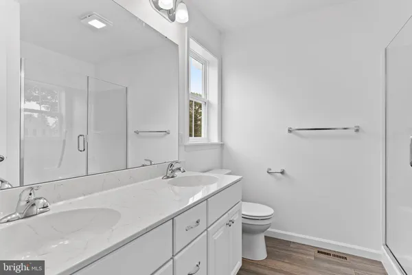 a bathroom with a granite countertop sink a toilet and a mirror