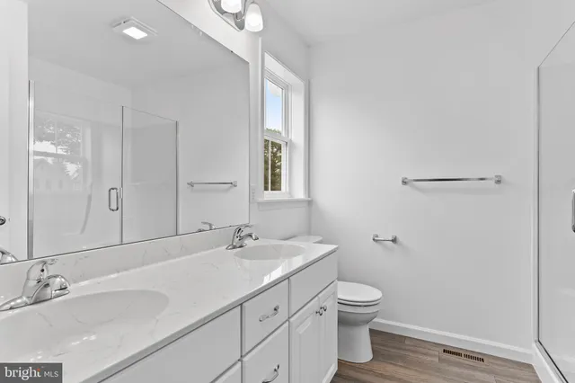a bathroom with a granite countertop sink a toilet and a mirror