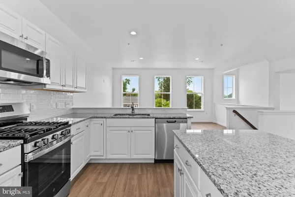 a kitchen with stainless steel appliances granite countertop a sink stove and microwave