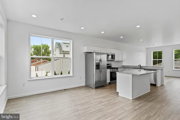 a kitchen with stainless steel appliances granite countertop a refrigerator and a stove top oven