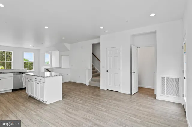 a large white kitchen with wooden floors and white cabinets
