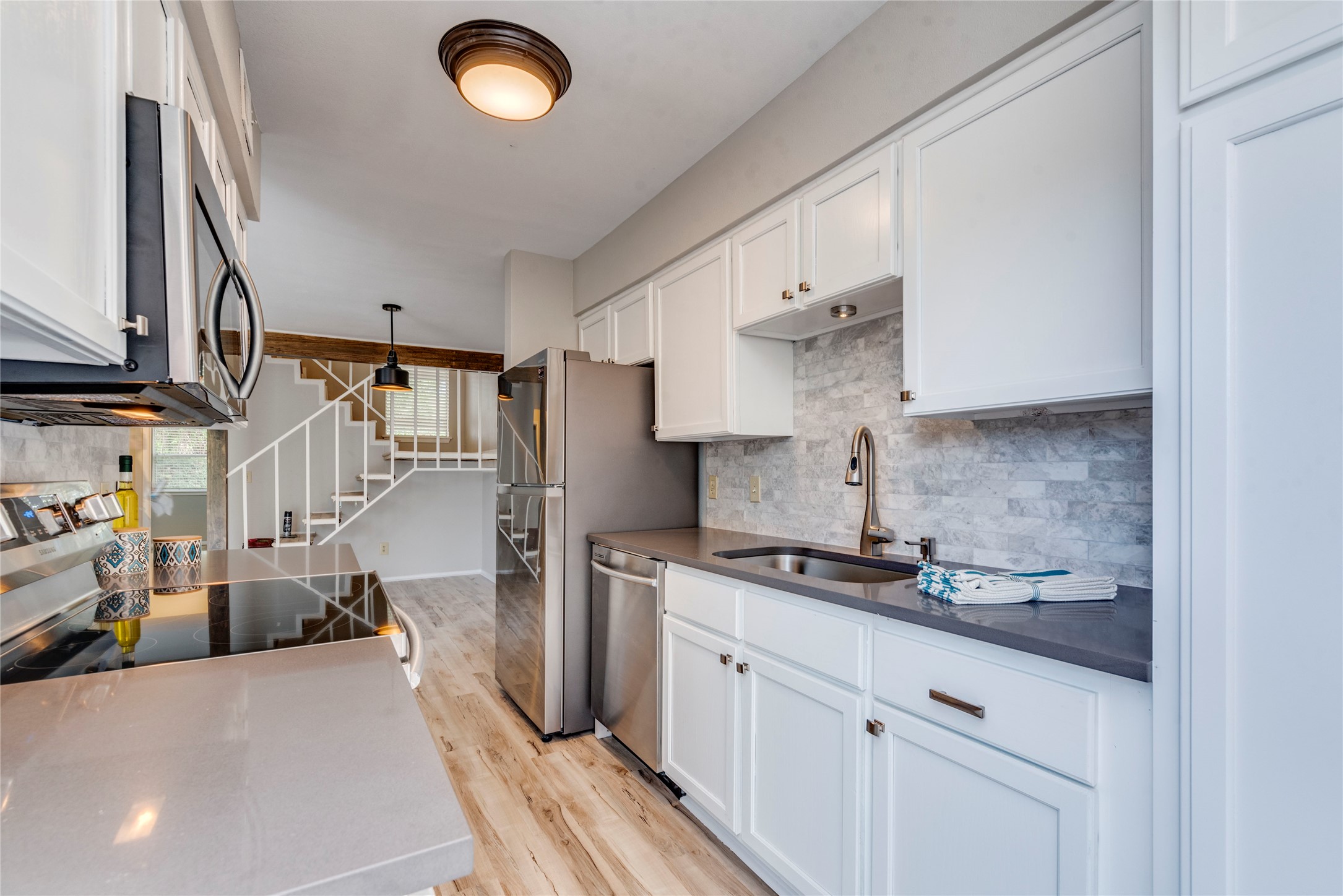 a kitchen with stainless steel appliances granite countertop a sink dishwasher stove and refrigerator