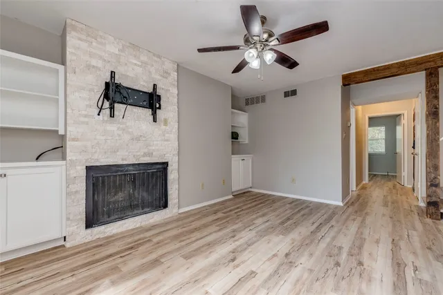 a view of empty room with wooden floor and fireplace