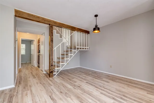 a view of a hallway with wooden floor and staircase
