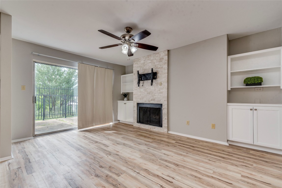 6910 Hart Lane, Unit 805 Austin, TX 78731 - Photo 6 of 17 a view of an empty room with a window and wooden floor