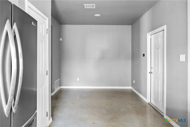 a view of a refrigerator in kitchen and entryway