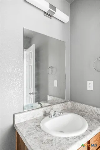 a bathroom with a granite countertop sink and a mirror