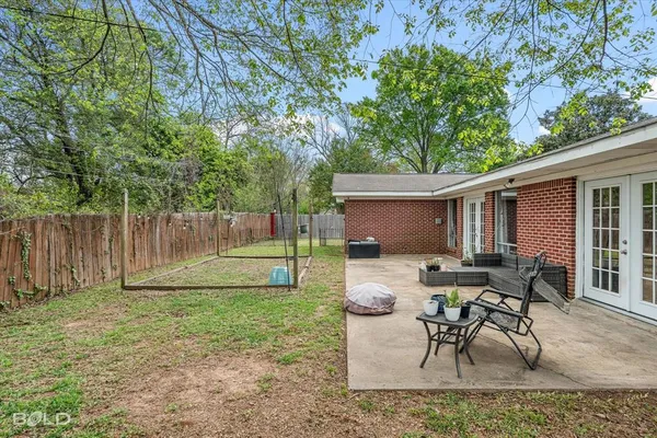 a backyard of a house with table and chairs