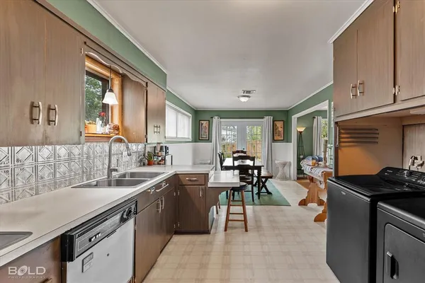 a kitchen with counter top space a sink stove and cabinets