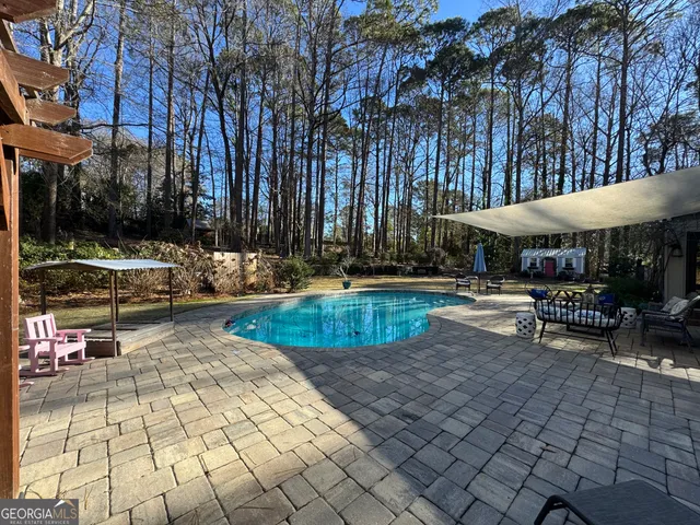 a view of a swimming pool with sitting area and furniture