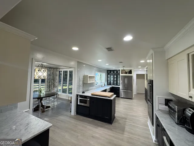 a kitchen with stainless steel appliances kitchen island granite countertop a stove and a sink