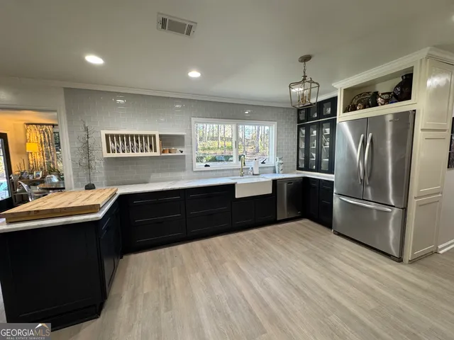 a kitchen with granite countertop a refrigerator and a sink