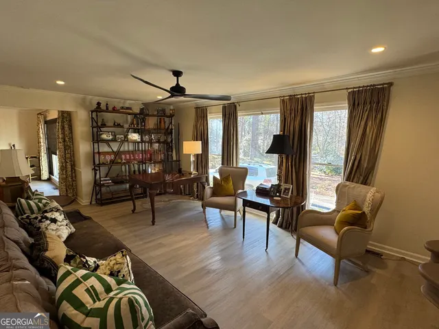 a living room with furniture two window and wooden floor