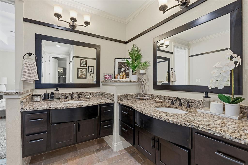 15317 Falconhead Grove Loop Austin, TX 78738 - Photo 6 of 29 Dual vanities with granite counters and rich cabinetry define this elegant primary bathroom.