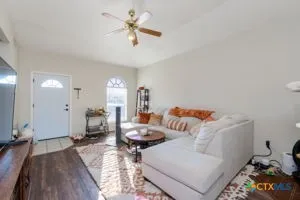 a living room with furniture and a wooden floor