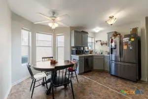a kitchen with a refrigerator a sink dishwasher a stove with a dining table and chairs