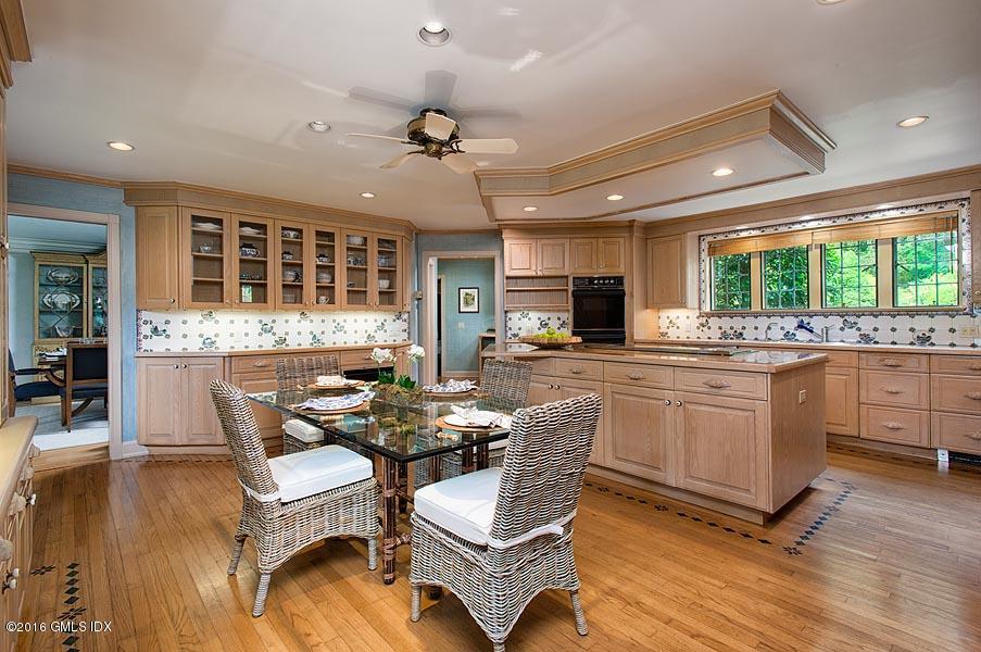 21 Konittekock Road Greenwich, CT 06831 - Photo 11 of 23 a kitchen with stainless steel appliances granite countertop a stove a sink dishwasher a dining table and chairs with wooden floor