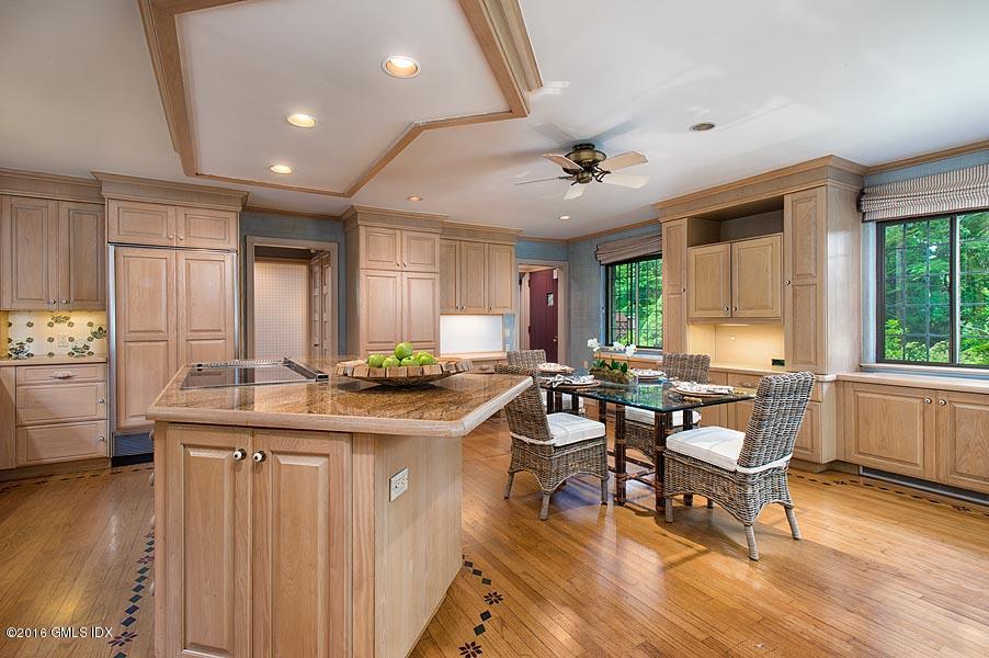 21 Konittekock Road Greenwich, CT 06831 - Photo 12 of 23 a kitchen with stainless steel appliances granite countertop a stove a refrigerator a sink dishwasher with a dining table and chairs with wooden floor