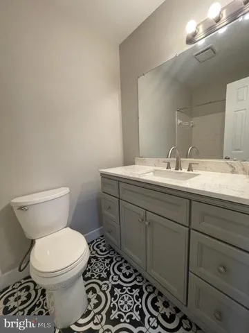 a bathroom with a toilet a sink and mirror