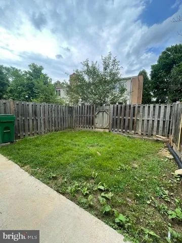 a view of a yard with a large trees and wooden fence