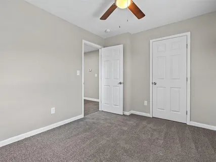 an empty room with chandelier fan
