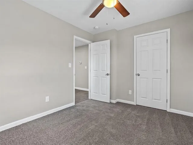 an empty room with chandelier fan