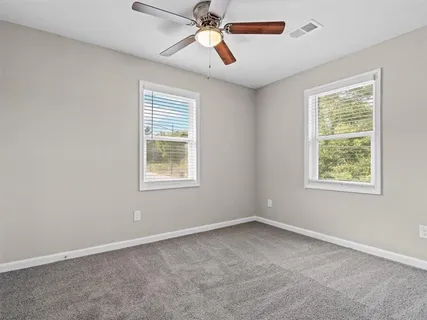 an empty room with a window and a fan