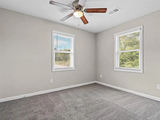 an empty room with a window and a fan