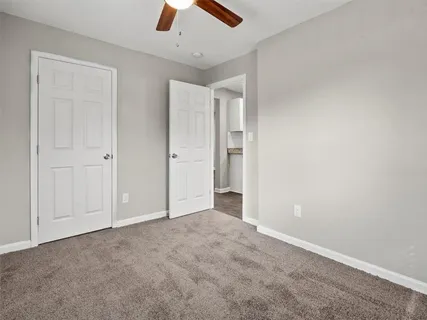 an empty room with closet and fan
