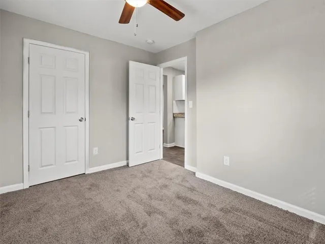 an empty room with closet and fan