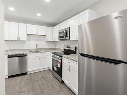a kitchen with white cabinets and stainless steel appliances
