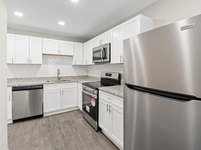 a kitchen with white cabinets and stainless steel appliances