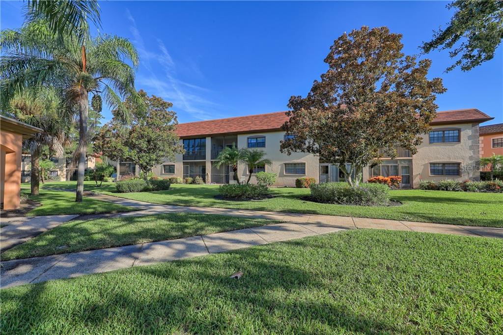 12900 Vonn Road, Unit E103 Largo, FL 33774 - Photo 1 of 1 a front view of a house with a yard