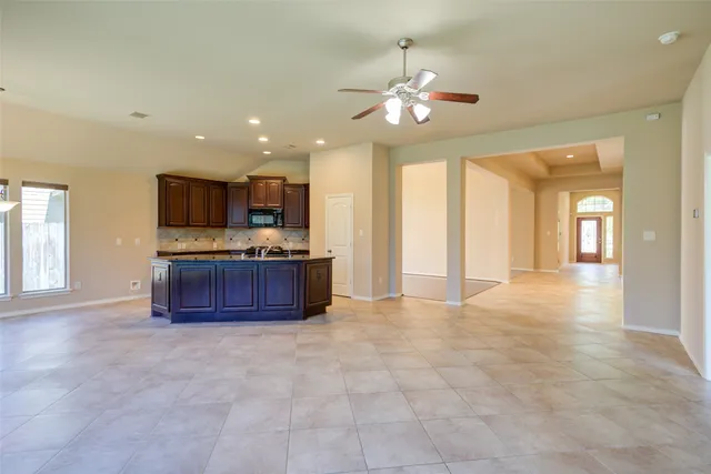 a large kitchen with kitchen island granite countertop a sink and a stove top oven