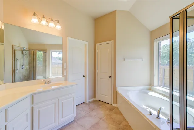a spacious bathroom with a granite countertop sink and a mirror