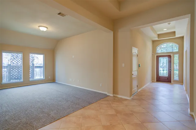 a view of a big room with windows and chandelier fan