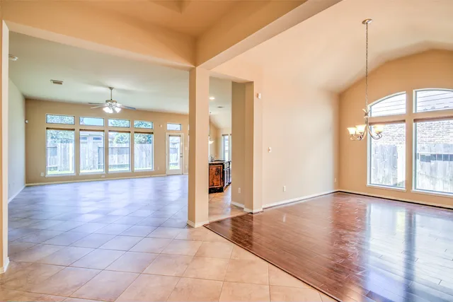 a view of an empty room with glass door and windows