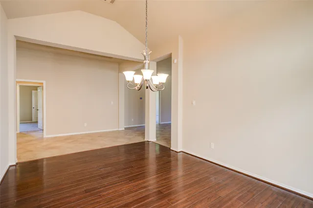 a view of a room with wooden floor and chandelier