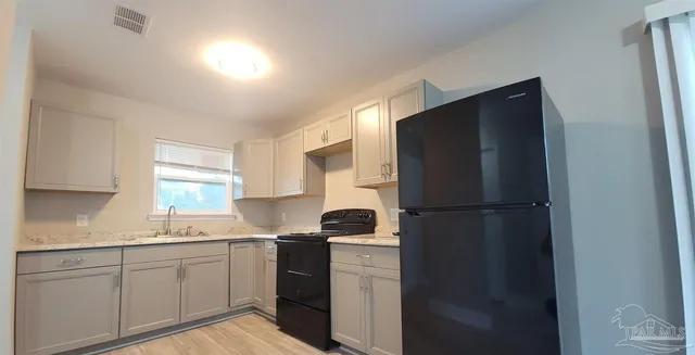 a kitchen with a refrigerator sink and cabinets