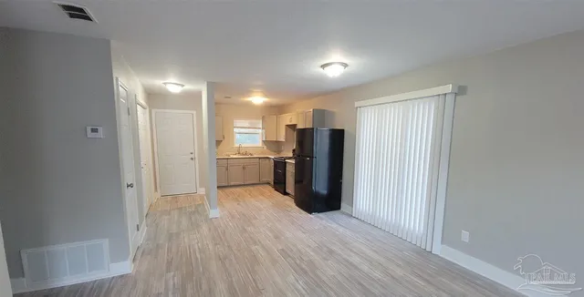 a view of a kitchen with refrigerator and wooden floor