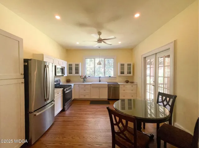 a kitchen with a refrigerator a stove dining table and chairs