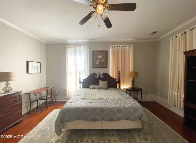 a bedroom with a bed chandelier and a window