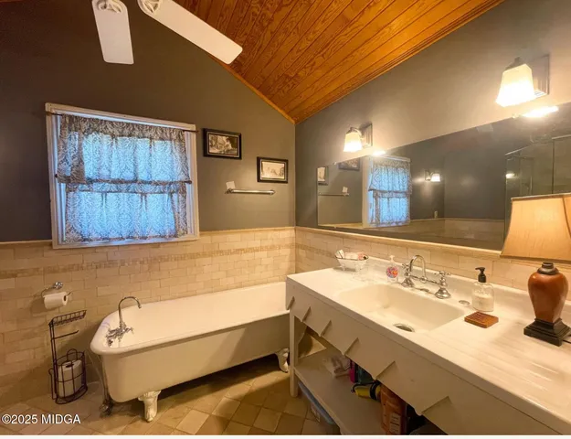 a bathroom with a tub sink and mirror